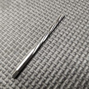 An AR15 Front Sight Base - Taper Pin Reamer is placed on a textured gray surface.