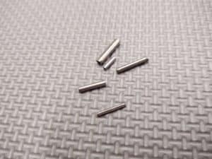 A set of 420 stainless steel coil/Spirol pins on a grey surface.