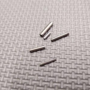 A set of 420 stainless steel coil/Spirol pins on a grey surface.