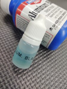 A 5ML Tube Loctite 620 with a blue liquid next to it.