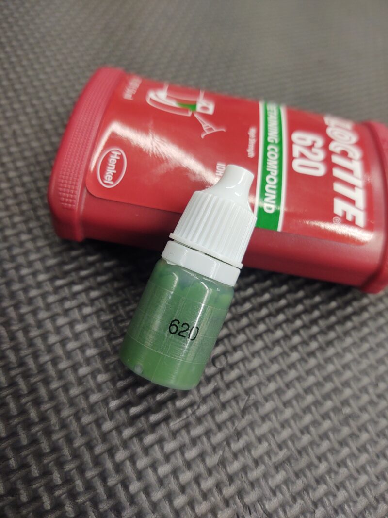 A 5ML Tube Loctite 620 of green liquid next to a red bottle.