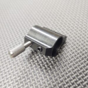 A small piece of metal with a 10-32 Gas Block/Gas Port Installation Thumb Screw on it.