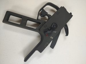 An HK PSG1 Trigger with HK91 Trigger Housing, featuring levers and a trigger-like mechanism, set against a white background.