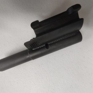 Close-up of an HK91 and Clones M-LOK Handguard, a black metal cylindrical object, resting on a light gray surface, showcasing its grooved slot and central hole.