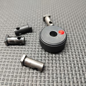 A SOTAR AR15 Cam Pin Field Gauge (Reject Gauge Only) and four metal components are placed on a textured gray surface.