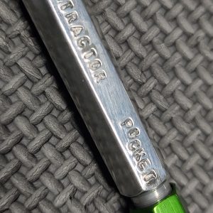 A close-up of the SOTAR AR Extractor Spring Pocket GO Gauge - MK4 (Copy) resting on a textured gray fabric surface.